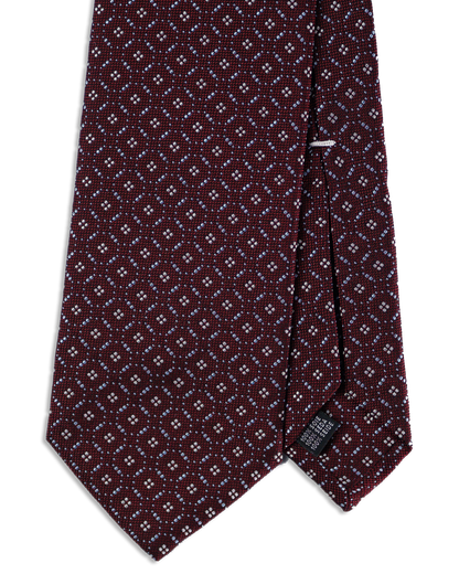 Nahaufnahme des Jacquard-Webmusters auf tiefroter Seidenkrawatte